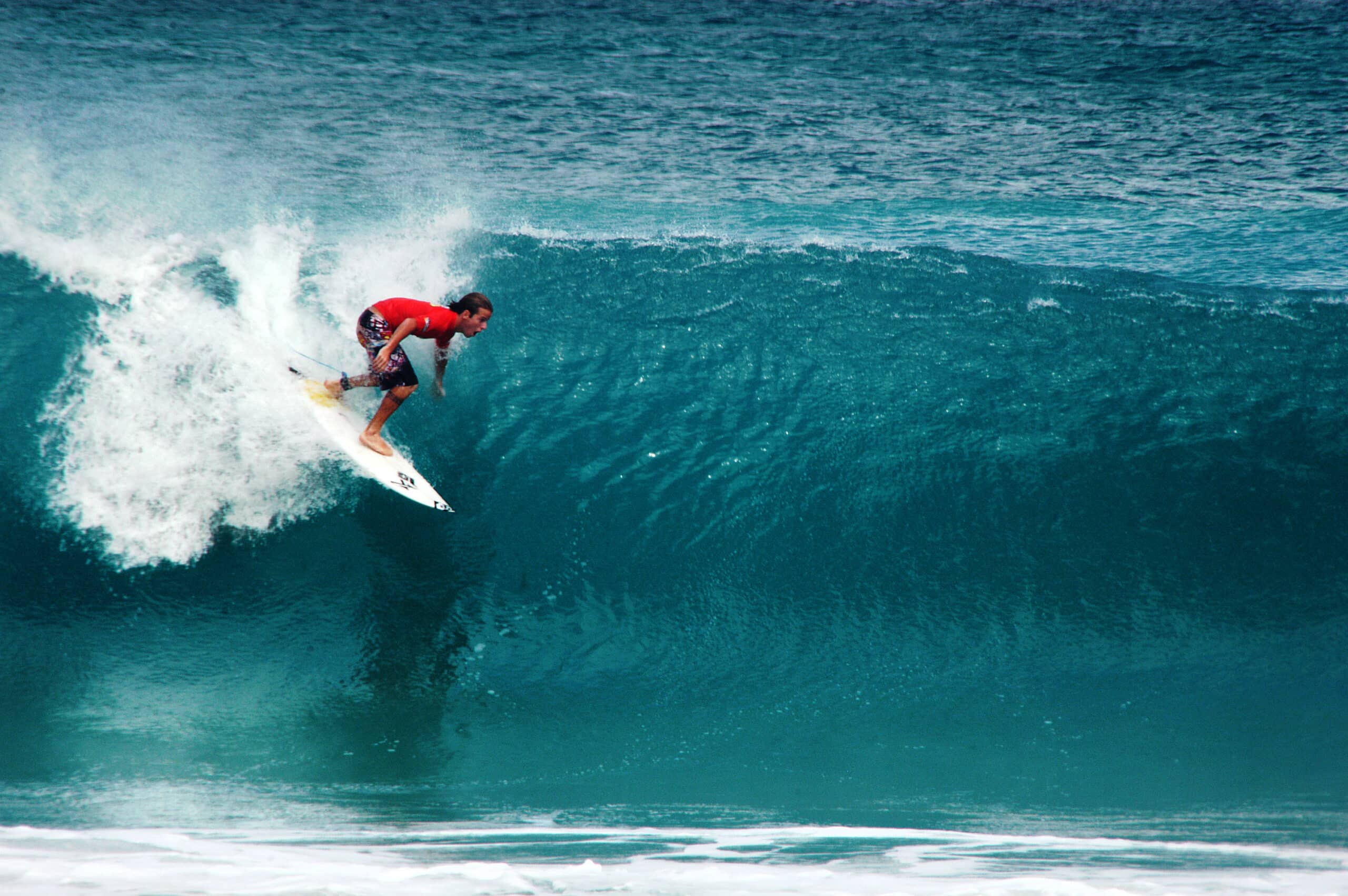 Homem surfando em sua prancha em uma onda na Praia Cacimba do Padre, em Fernando de Noronha.