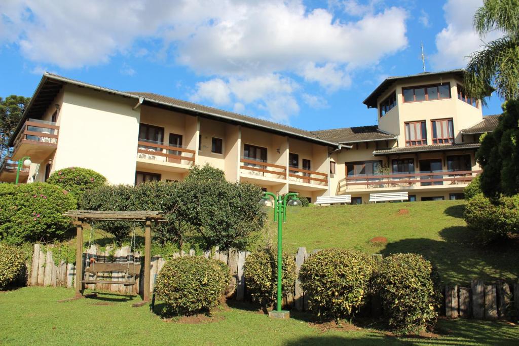 Imagem da frente do Hotel Estancia Betania durante o dia com gramados e arbusto a frente e ao fundo a estadia.