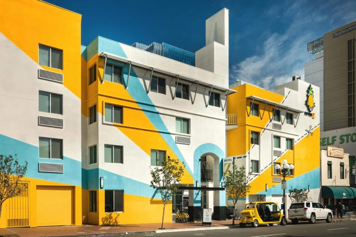 Foto da faixada do Staypineapple, Hotel Z. Ele é todo colorido e alguns carros estão estacionados na frente.