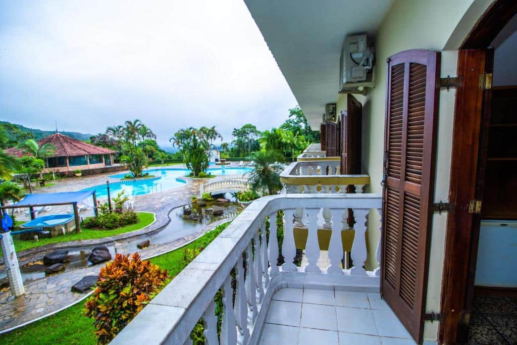 Imagem da varanda do Mata Atlântica Park Hotel durante o dia com a estadia do lado direito com varanda e do lado esquerdo o jardim com piscina.