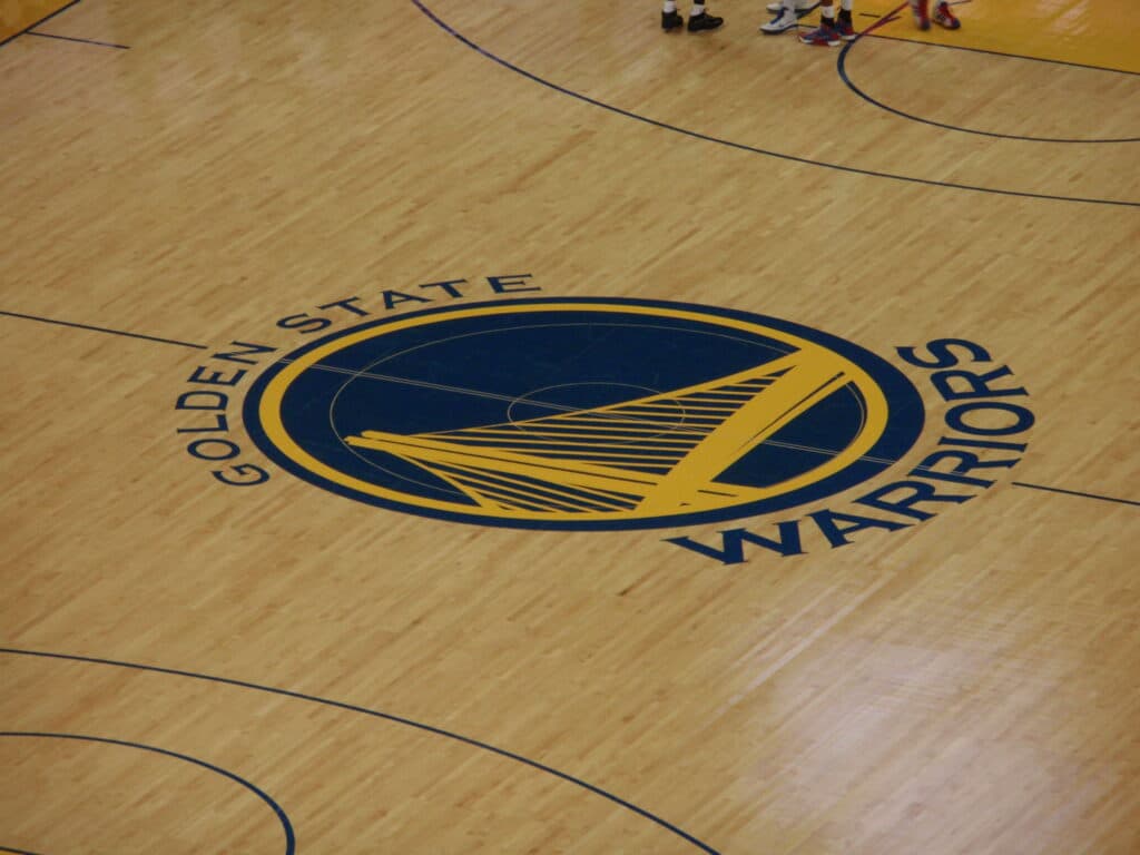 Quadra de basquete com o logotipo do Golden State Warriors no centro da quadra.