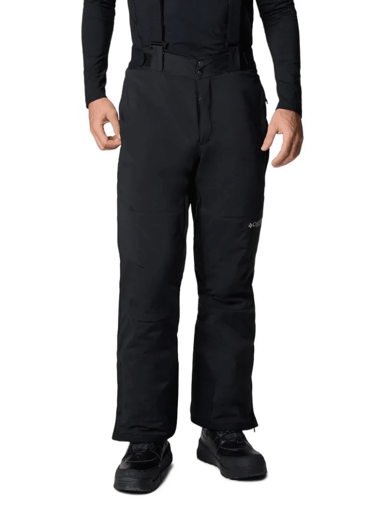 Uma pessoa vestindo calças de neve pretas e botas está de pé sobre um fundo branco simples.