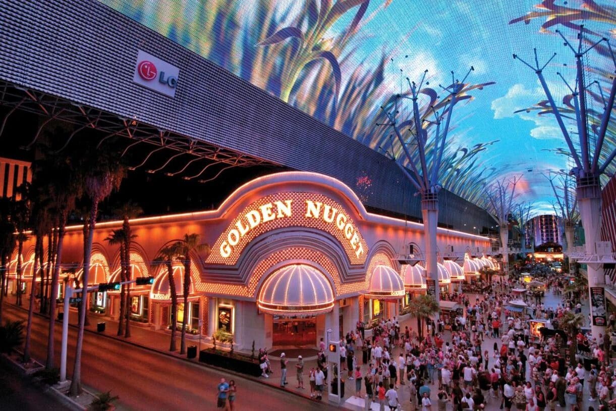 Multidões se reúnem sob um dossel decorativo e bem iluminado no Golden Nugget, na Fremont Street, em uma agitada vida noturna.