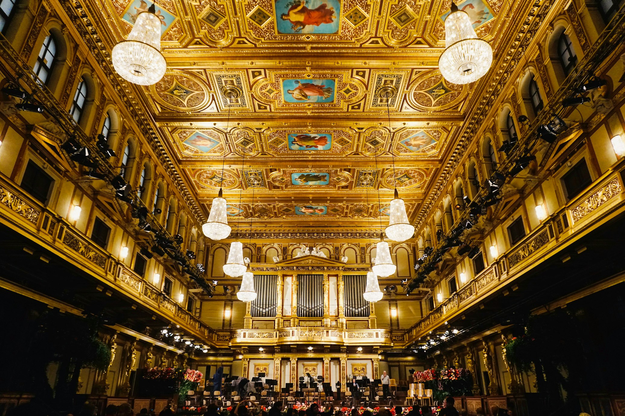 Interior do Musikverein ornamentado com teto dourado e decorado, lustres e vista do palco e do órgão.