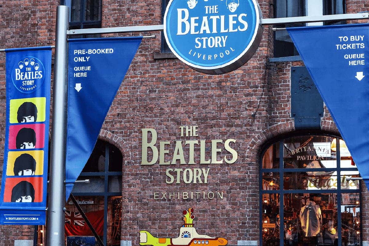 Entrada para a exposição The Beatles Story em Liverpool, com faixas e uma decoração de submarino amarelo em um prédio de tijolos.