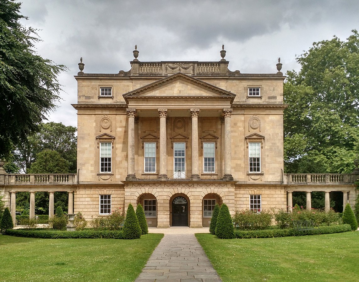 The Holburne Museum, um edifício e museu neoclássico com colunas altas e telhado com frontão, cercado por gramados e árvores bem cuidados sob um céu nublado. Essa é uma boa opção de o que fazer em Bath.