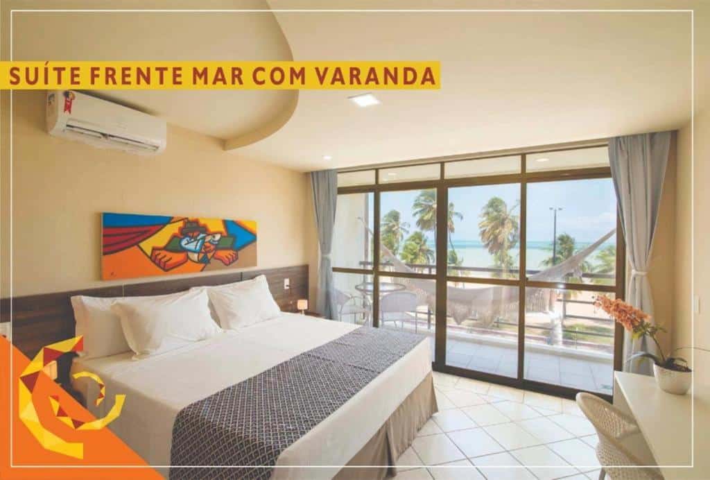Um quarto no Netuanah Praia Hotel na Praia de Cabo Branco, com uma cama grande, arte na parede, portas de vidro, varanda, rede e vista para as palmeiras e o oceano, para representar hotéis em João Pessoa.