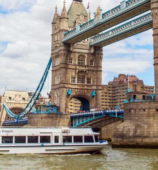 Um barco de cruzeiro pelo Tâmisa de Westminster à Tower Bridge. Está sob a Tower Bridge em Londres.