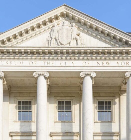 A fachada do Museu da Cidade de Nova York apresenta colunas, paredes de tijolos e um frontão branco com entalhes. A foto é capa do post Ingresso do Museu da Cidade de Nova York.