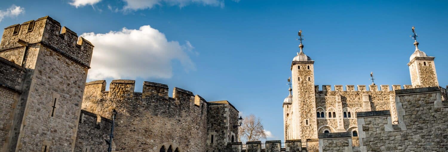 Muralhas medievais e várias torres em um céu azul. Ingresso da Torre de Londres