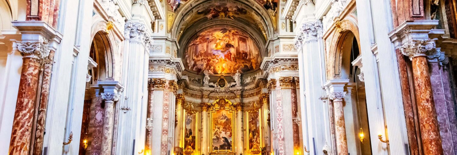 Interior de uma igreja barroca com colunas ornamentadas, tetos em arco e afrescos detalhados acima do altar no Free tour pelas igrejas barrocas