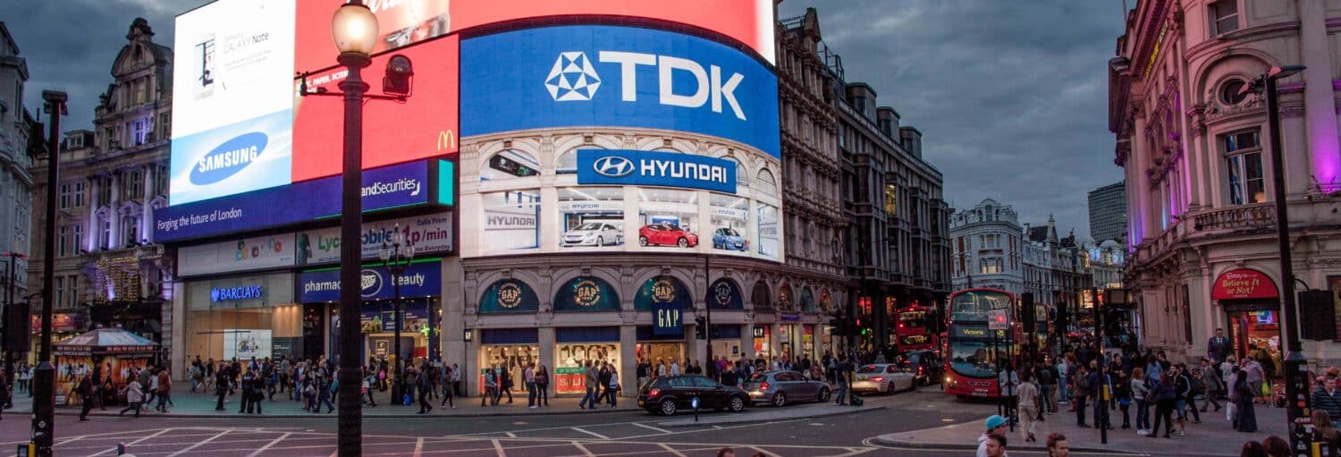 Um grande outdoor em um prédio histórico em Londres. O céu é nublado. Free tour pelo Soho