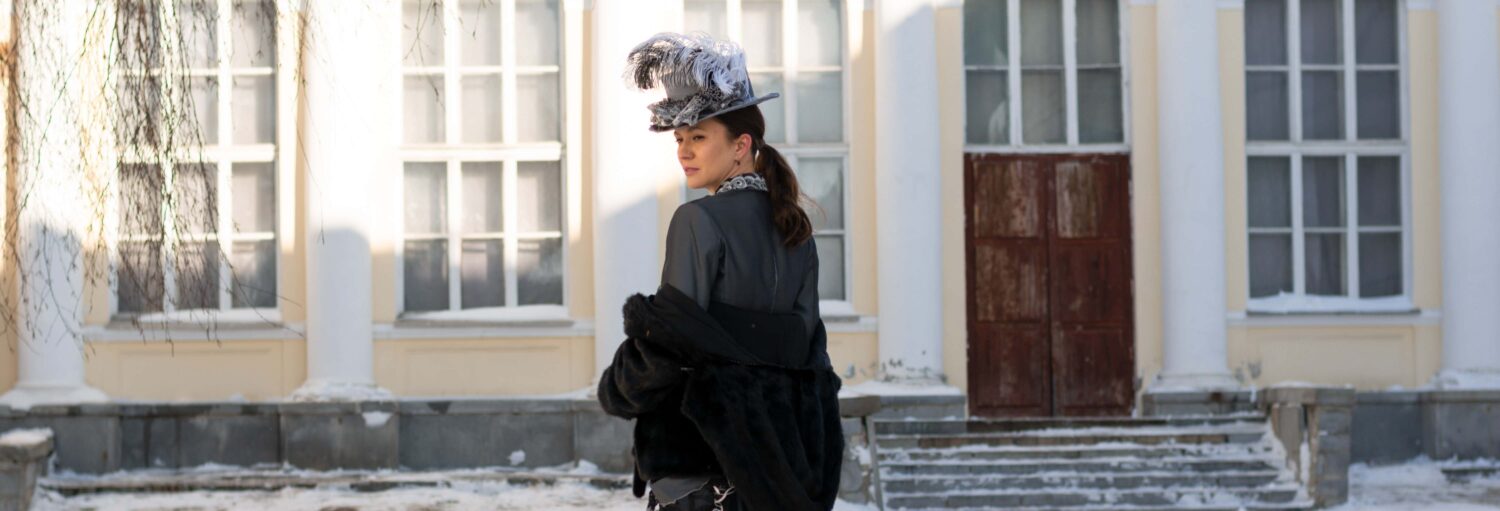 Uma dama com roupas de época na frente de uma casa histórica. Tour de Bridgerton por Londres