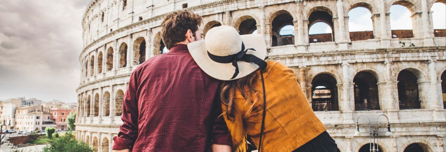 Duas pessoas estão próximas uma da outra em frente ao Coliseu, em Roma, de costas para a câmera no Tour fotográfico de Roma