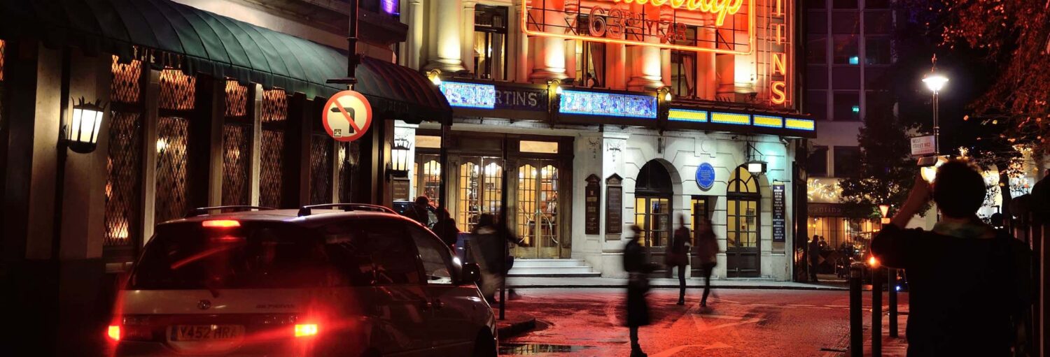 Uma rua em Londres à noite com lojas abertas. Tour noturno pela Londres atual