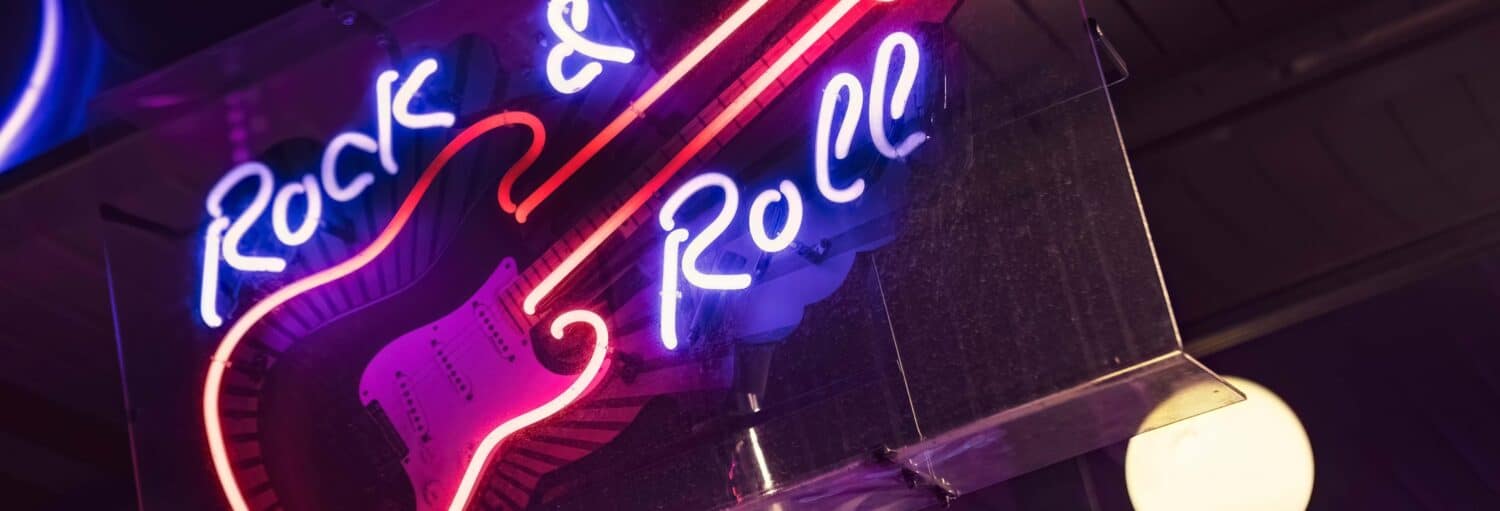 Uma placa de neon em formato de guitarra com as letras "Rock & Roll". Tour do rock britânico por Londres