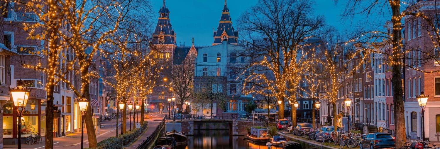Rua em Amsterdam decorada com luzes de natal. Barco natalino de Amsterdam