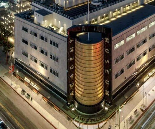 Um edifício com um grande edifício redondo. A foto é capa do post da Ingresso do Academy Museum of Motion Pictures.