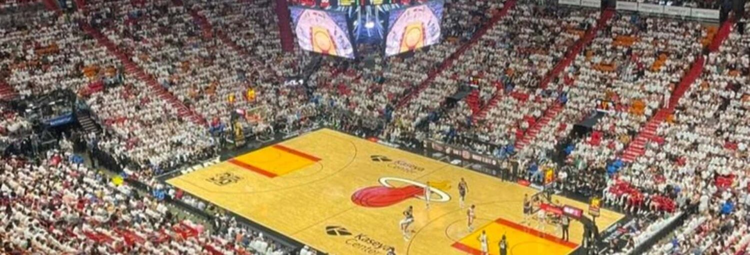 Vista ampla de uma arena de basquete lotada enquanto os torcedores com ingresso da NBA Miami Heat torcem durante um jogo emocionante.