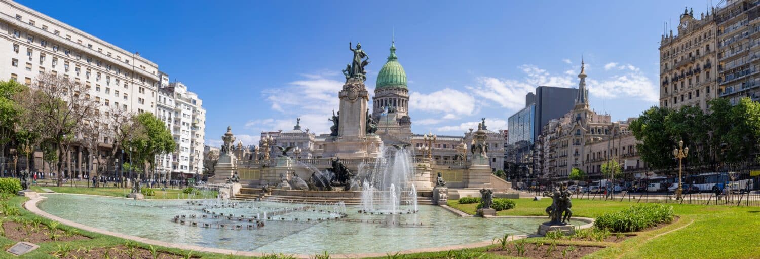 Vista panorâmica de uma grande fonte e estátua em frente a um prédio governamental com cúpula e prédios da cidade ao redor. Imagem para ilustrar post sobre a excursão de 2 dias a Buenos Aires.