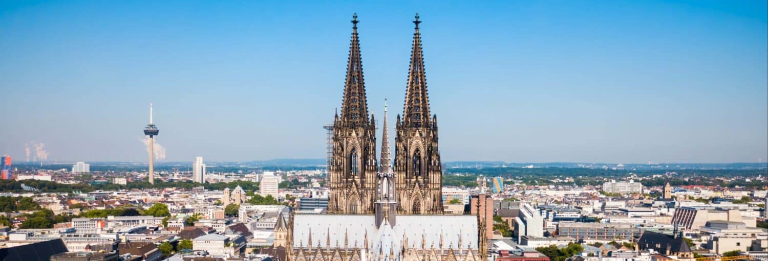 duas torres grandes e góticas no meio de uma vasta cidade. Excursão a Colônia e Antuérpia