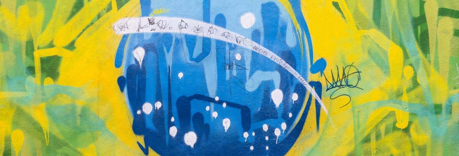 Grafite do Tour de street art pelo Rio de Janeiro: uma esfera azul com pontos brancos em um fundo abstrato verde e amarelo.