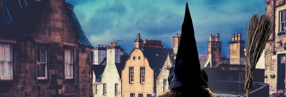 Uma pessoa com um chapéu preto pontudo e uma capa está em um telhado perto de uma vassoura, com vista para velhos edifícios de pedra. A foto é capa do post do Tour das buxas de Edimburgo.