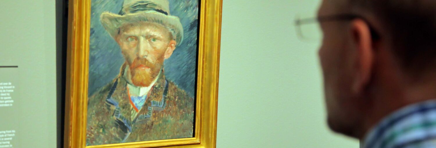 Um retrato de Van Gogh em um quadro em uma parede verde. Visita guiada pelo Museu Van Gogh