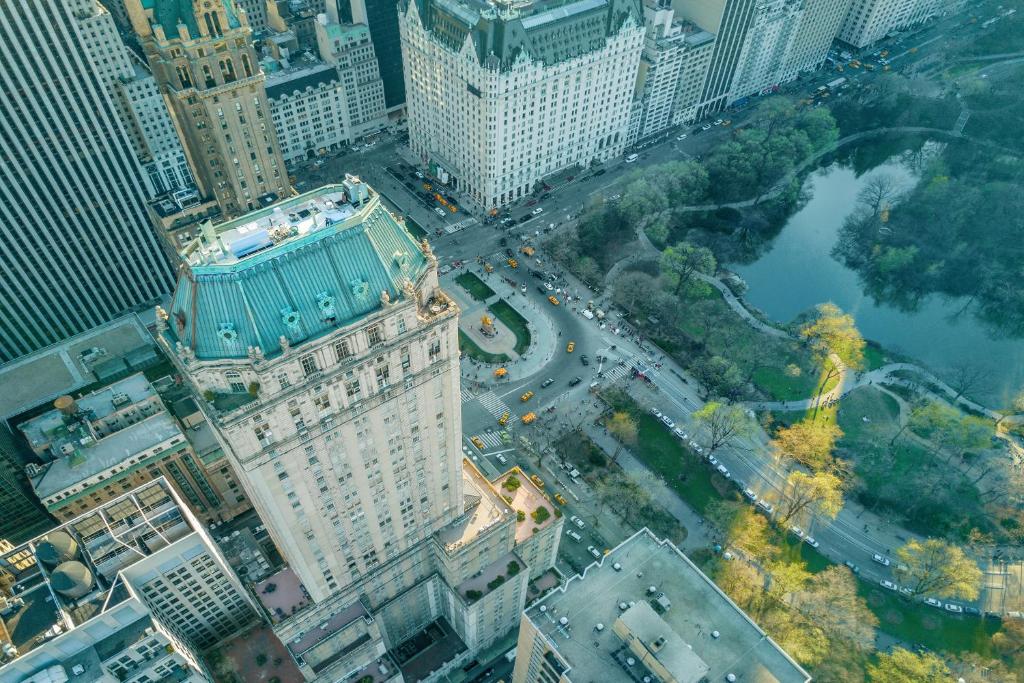 Vista aérea de edifícios altos próximos ao Central Park com árvores, estradas e táxis amarelos na cidade de Nova York.