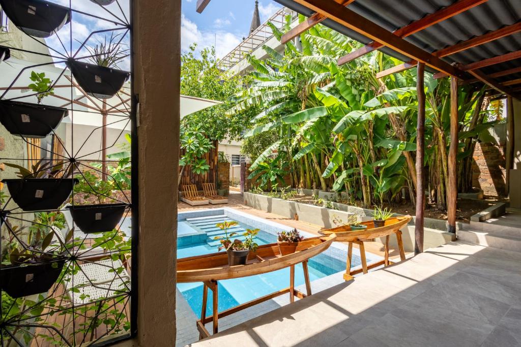 Pátio externo com uma pequena piscina, vasos de madeira na água e plantas tropicais exuberantes ao redor da área, no Hotel Casa do Bispo. Representa hotéis em Manaus.