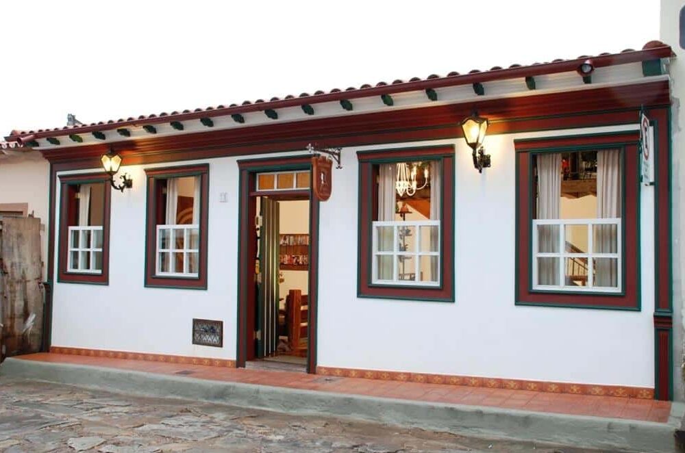 Uma casa branca com acabamento vermelho na Pousada Vila do Imperador.