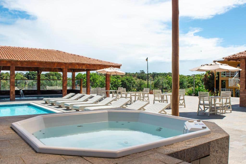 Área de lazer com piscina e espreguiçadeiras na Pousada Vila do Sol com paisagem natural exuberante