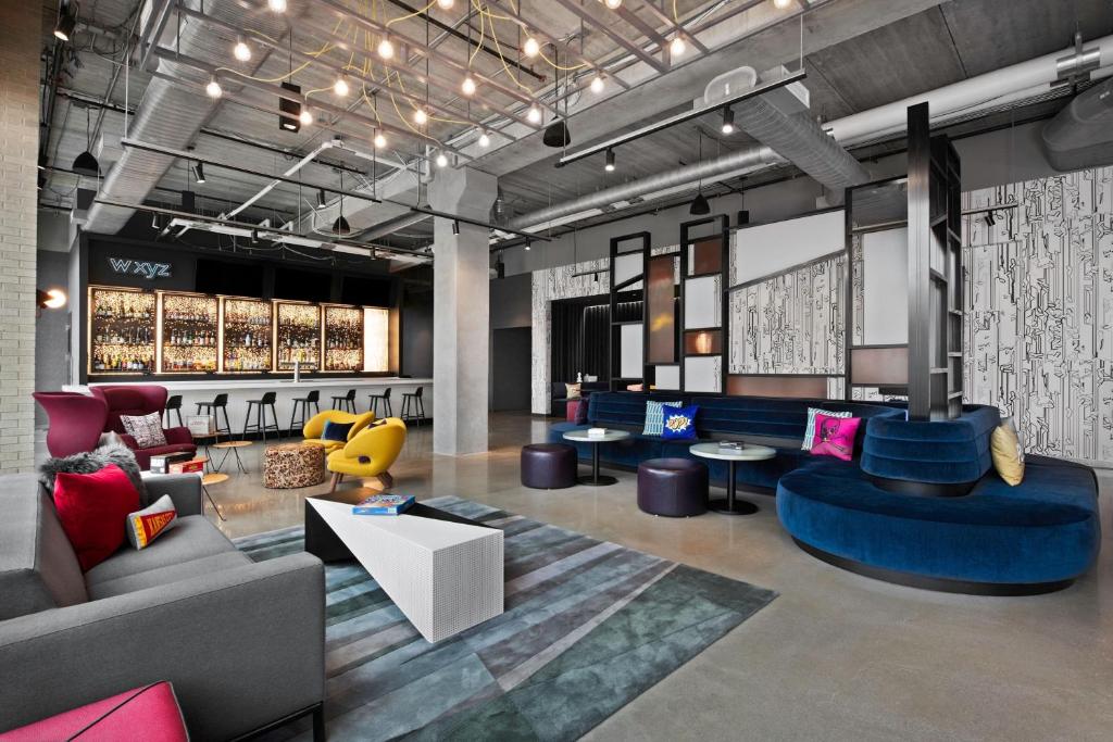 Espaço de trabalho e lounge modernos com móveis coloridos e decoração industrial no Aloft Kansas City Country Club Plaza.