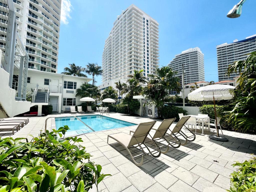 Piscina do Aqua Hotel com espreguiçadeiras em área externa de complexo de edifícios residenciais modernos e luxuosos. Imagem para ilustrar post sobre onde ficar em Fort Lauderdale.
