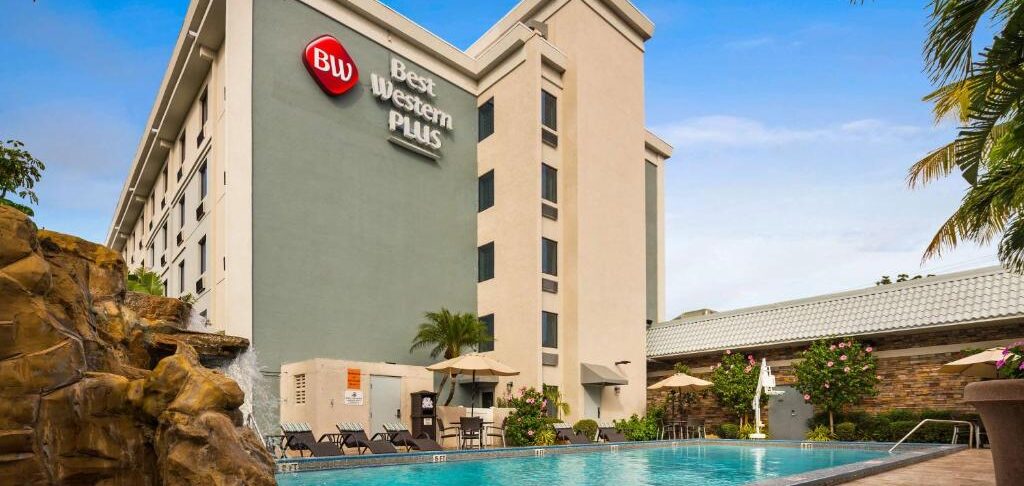 Best Western Plus Hollywood/Aventura com piscina ao ar livre em ambiente tropical com palmeiras