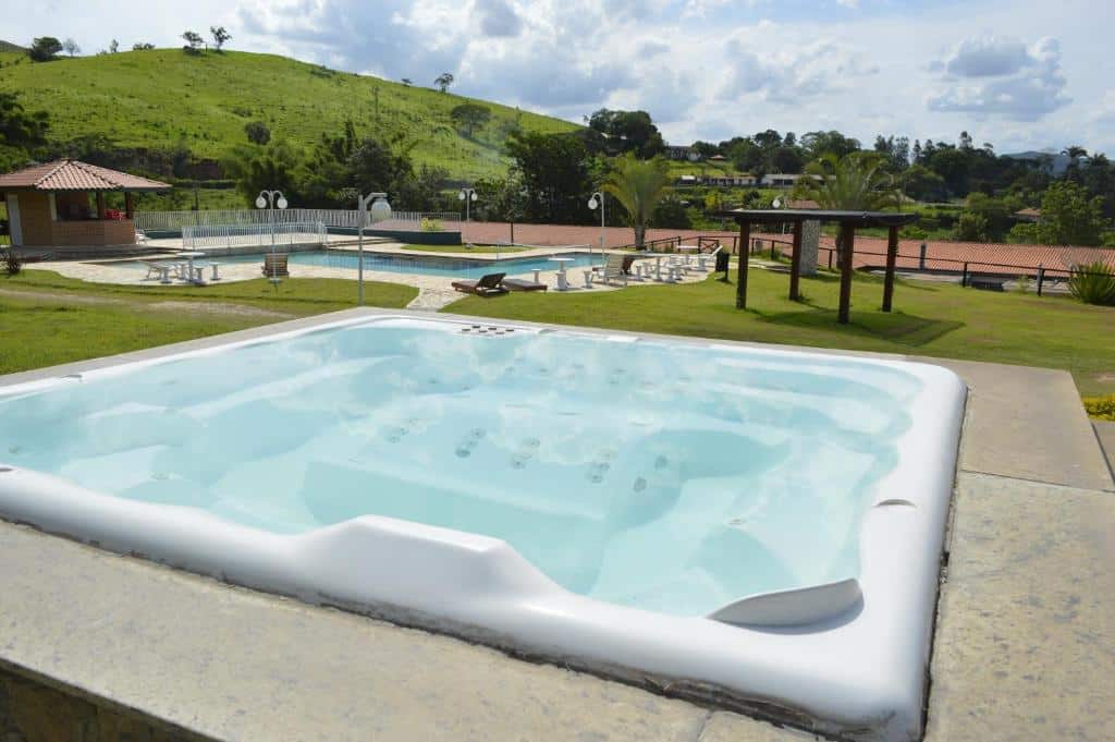 Área verde do Bougainville Hotel Fazenda com hidromassagem ao ar livre e piscina.