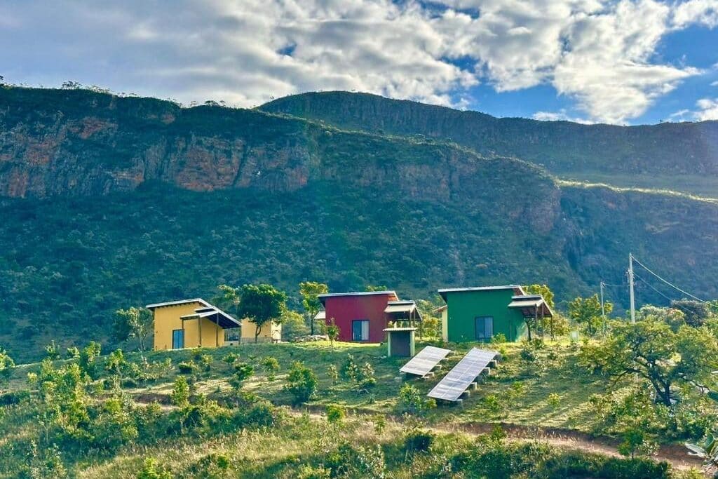 três Cabanas coloridas dos chalés canário de minas em paisagem de montanhas e vegetação exuberante na serra da canastra