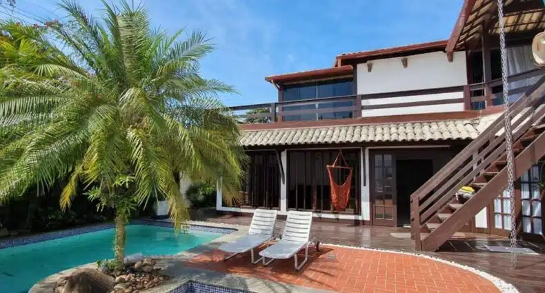 Casa de campo do Guesthouse Mata da Praia com piscina em ambiente tropical, durante um dia com poucas núvens e céu azul. Representa as pousadas em Vitória