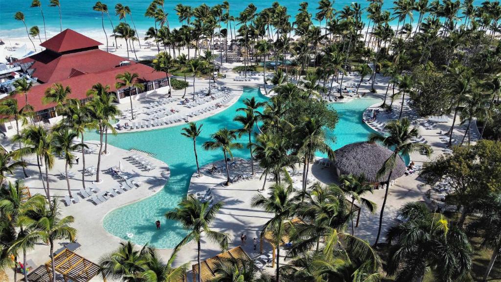 Complexo do resort Grand Bavaro Princess, em Punta Cana, com piscinas e palmeiras em paisagem tropical.
