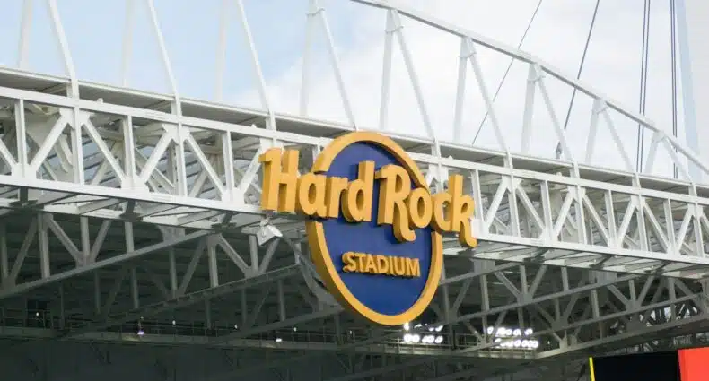 Estádio Hard Rock com estrutura metálica branca em formato de arco. A imagem ilustra o post sobre onde ficar perto do Hard Rock Stadium.