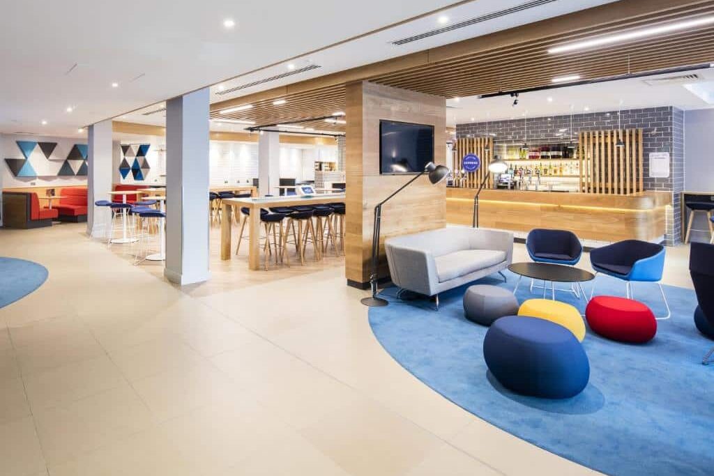 Recepção aconchegante do Holiday Inn Express Dublin City Centre com móveis coloridos e design criativo.