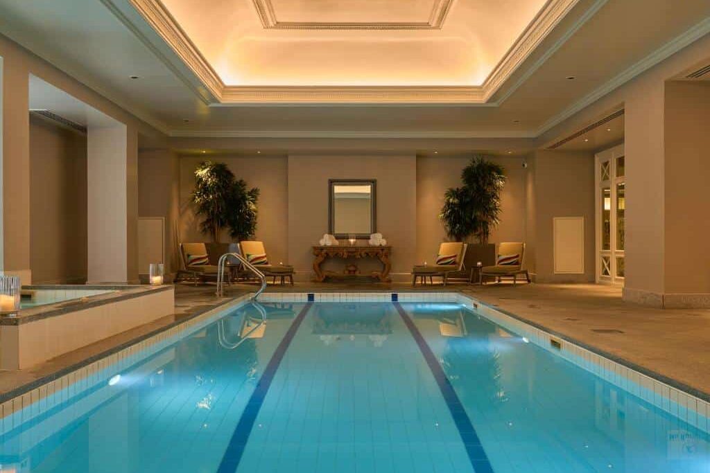 No InterContinental Dublin by IHG, uma piscina interna de luxo com chaise-longues e plantas ornamentais em ambiente sofisticado com teto alto.