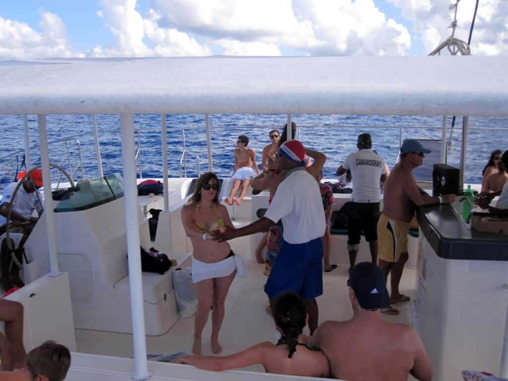 Grupo de pessoas curtindo passeio de barco indo para Isla Saona. No barco, é possível ver bancos e balcões.