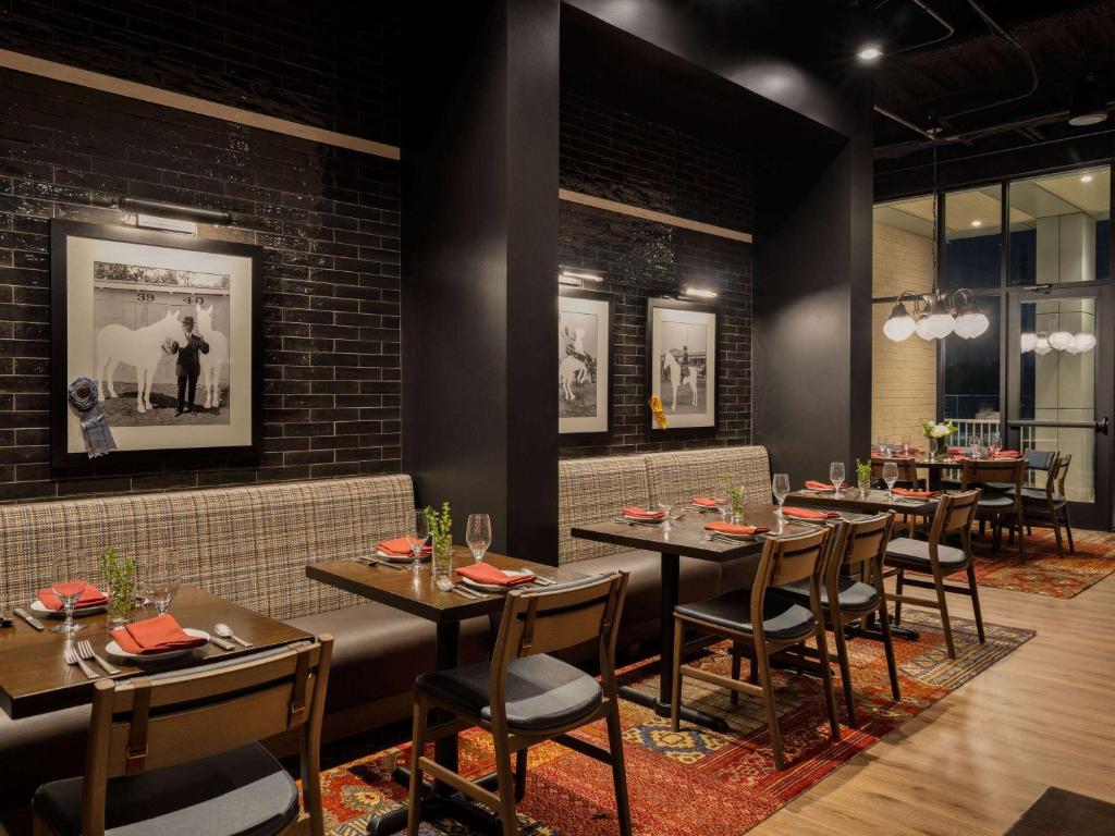Restaurante aconchegante do Origin Kansas City Riverfront com paredes de tijolos aparentes, quadros antigos e móveis de madeira rústicos, criando um ambiente sofisticado e elegante para refeições.