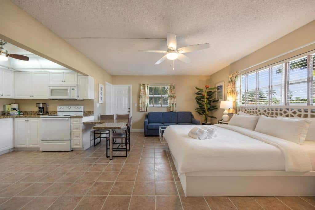 Aconchegante apartamento do Coconut Bay Resort com cozinha, sala de estar e quarto em tons neutros, com mobiliário moderno e decoração minimalista.