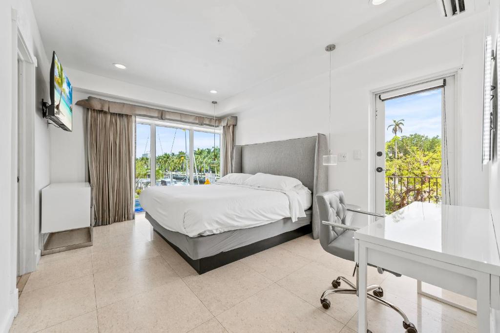 Amplo quarto do Isle of Venice com cama de casal e vista para a vegetação externa através das janelas panorâmicas.