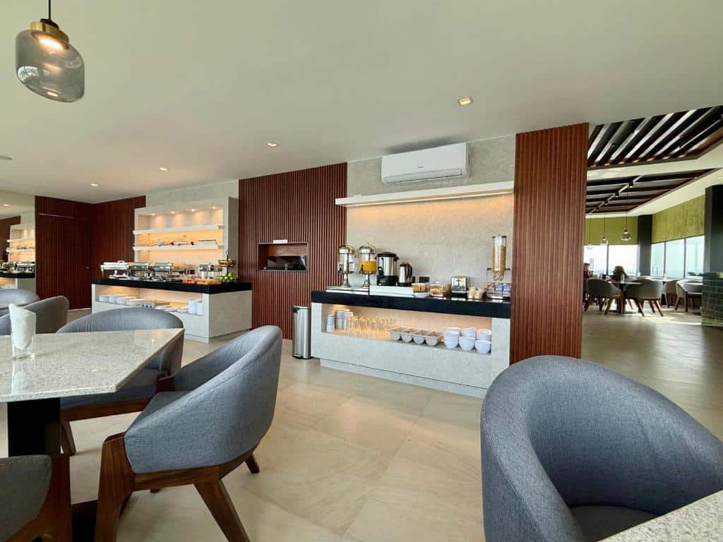 Elegante cafeteria com móveis modernos e bem equipada, perfeita para refeições e reuniões em ambiente agradável e acolhedor, do Hotel Myst. Representa hotéis em Monterrey.