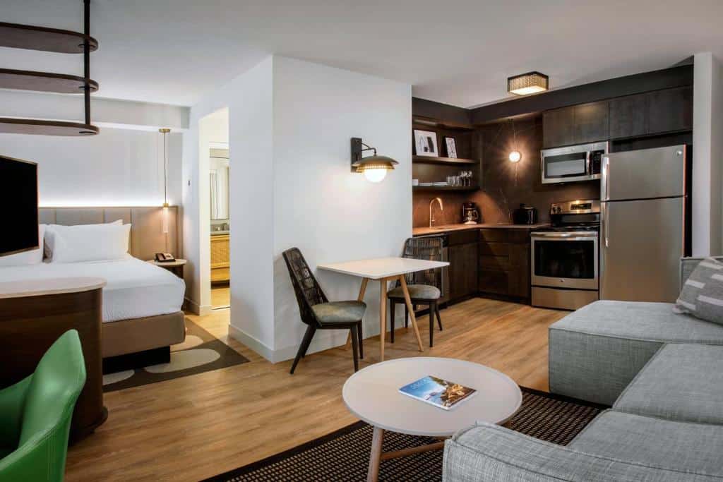 Quarto do Residence Inn by Marriott Miami Aventura Mall com área de estar, cozinha compacta e varanda. Essa é uma das dicas de onde ficar perto do Hard Rock Stadium.