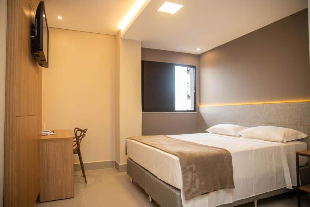 Quarto de hotel Serravita sofisticado com cama de casal confortável, decoração neutra e iluminação aconchegante. Ilustra onde ficar na serra da canastra