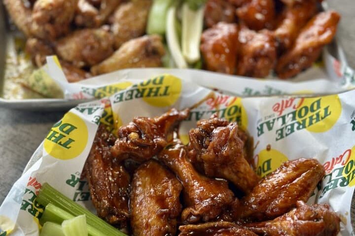 Bandeja com porção generosa de asas de frango cobertas em molho picante no restaurante Three Dollar Cafe, em Atlanta.